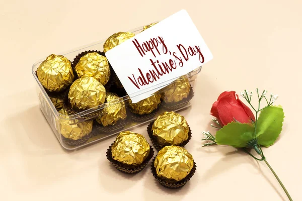 box of golden premium chocolate sweets with  happy valentine\'s day card, rose flower for valentine\'s holiday