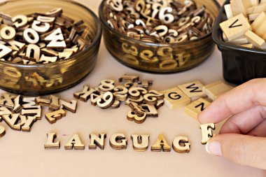 El kadın küçük ahşap harfler ile dil metni şekillendirme