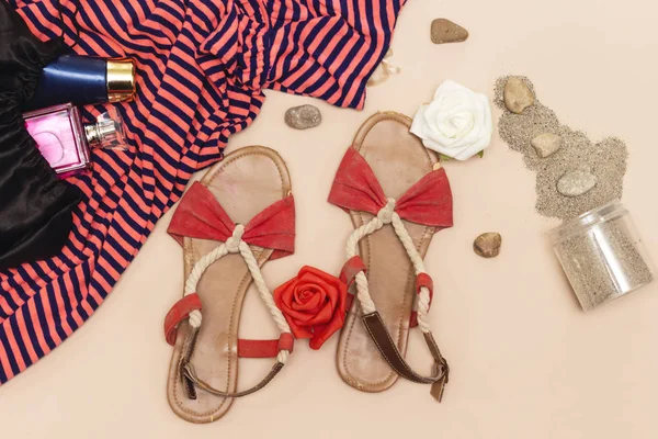 Yaz kavramı, plaj sandalet ve mavi krem tüp ve maxi elbise, şişe parfüm ve kum kavanoz, taşlar ve gül çiçek