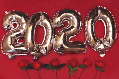 kırmızı gül, yeni yıl kavramı kırmızı zemin üzerine izole 2020 ballon numaraları