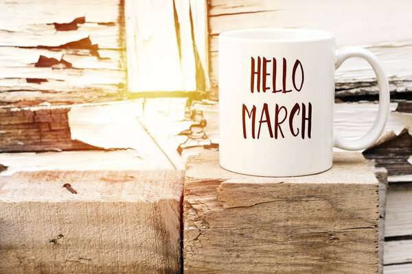 текст HELLO MARCH on cup of aromatic coffee on wooden cube

