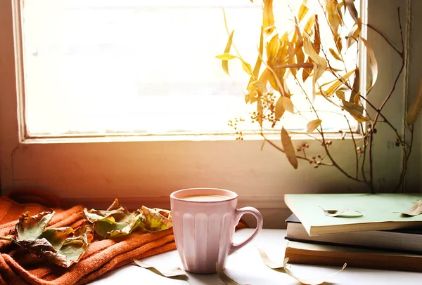 Hello Autumn card. Autumn still life. cup of coffee, orange scarf  and maple leaves on wooden background. the concept of cozy autumn.