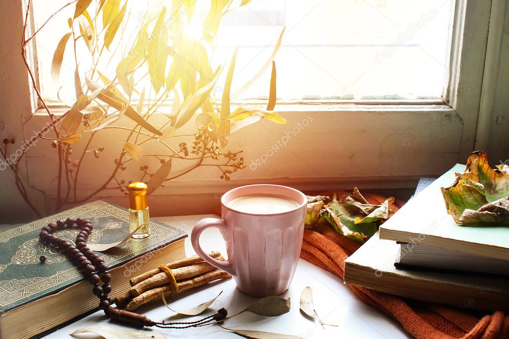 Autumn still life for muslim tradition m. cup of coffee,  orange scarf and maple leaves, holy book quran and rosary, siwak, on wooden background. the concept of cozy autumn.