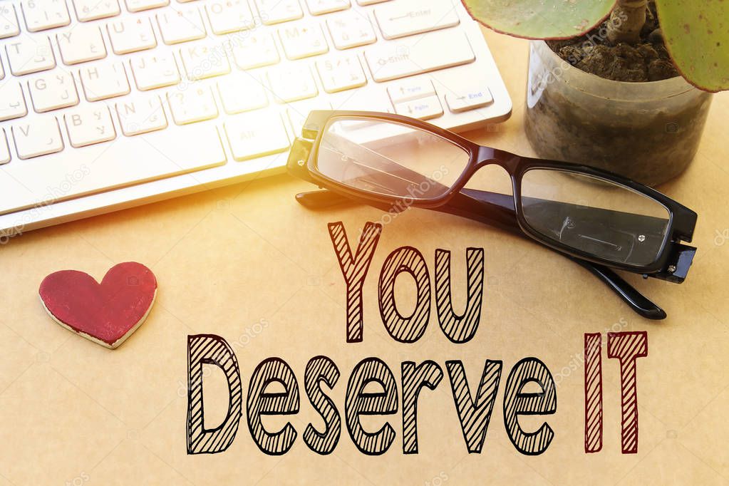 Word writing text You Deserve It. Business concept for Reward for something well done Deserve Recognition award, white keyboard and eyeglasses, pot plant