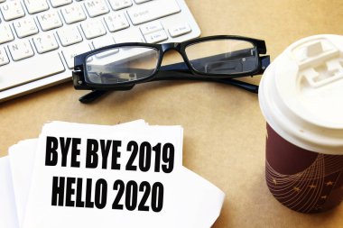 Hoşça kal Hoşça kal 2019 Merhaba 2020 beyaz kağıt üzerinde kahve ve gözlük, beyaz klavye ile