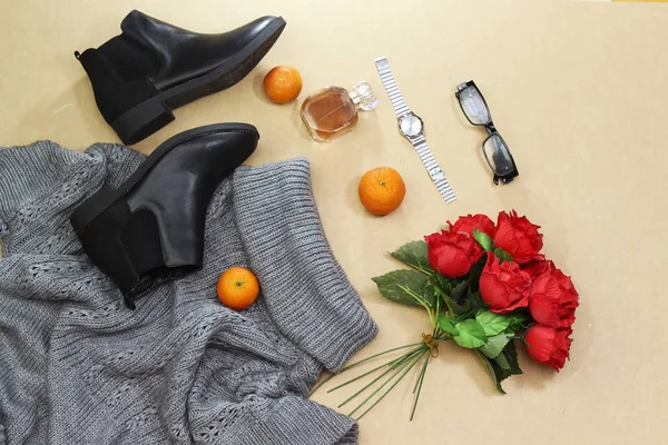 一套女人的秋天 冬天的衣服 灰色套头衫超大 黑色靴子和围巾 玻璃香水瓶 银手手表 橘子水果 时尚的散步服装 — 图库照片
