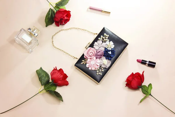 美しいバラの花と女性花黒クラッチ センターとボトルの香水 ピンクの背景に分離された結婚式バッグ — ストック写真