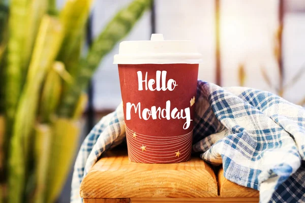 text HELLO MONDAY on cup of aromatic coffee on wooden table