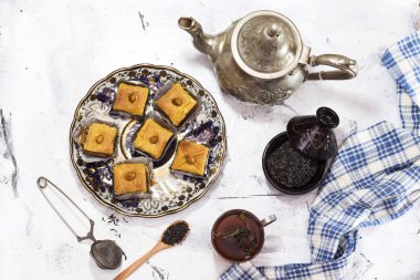Ramazan ve içme Arapça çay, çay kase ve gümüş çaydanlık, cam, tahta kaşık stand kek üzerine badem ile ev yapımı geleneksel Cezayir badem ve bal baklava