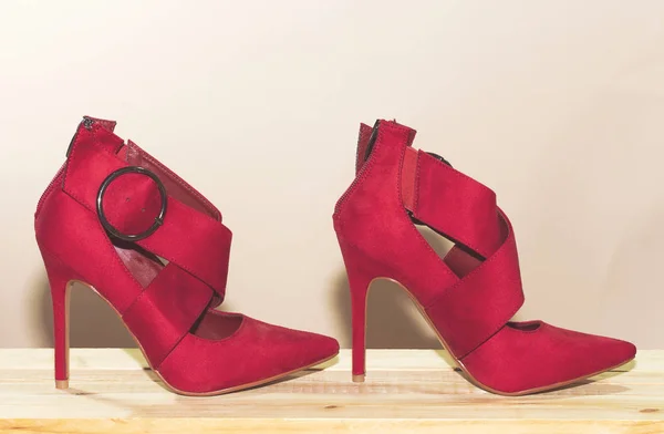 beautiful red high heels on wood table with red background