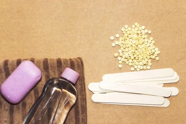 Damalı inci sarı katı balmumu fasulye ve ahşap sopa ahşap, mor sabun ve yağ şişesi