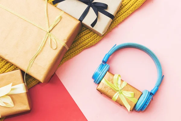 Christmas music gift concept. Headphones and gift boxes on colorful background