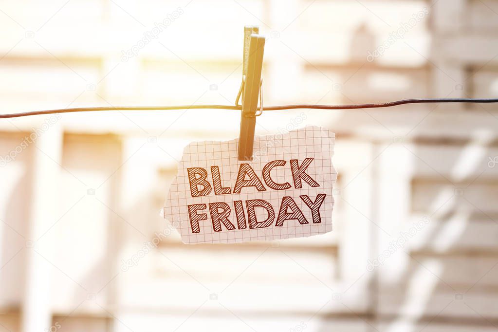 tear paper with black friday text  on metal clothesline outdoor