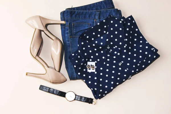 blue blouse and blue jeans, hand watch, earrings, pink heels. Women\'s spring summer basic outfit. Apparels flat composition