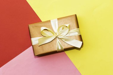 Üç renkli kağıt üzerinde dikdörtgen hediye kutusu: kırmızı, sarı ve pembe