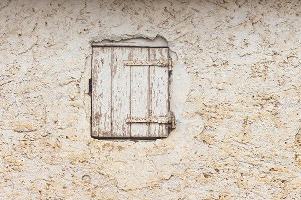 old Wooden window on a wall. Detail of a closed wooden window on a wall