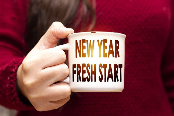 Hands Holding a Coffee Mug With Text New Year Fresh Start