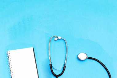 Stetoskop ve dizüstü bilgisayar, mavi arka plan üzerinde kardiyogram. Kardiyoloji kavramı