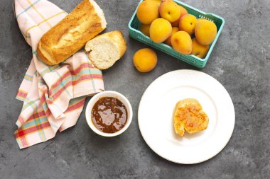 Kayısı reçelli kahvaltı ve bir dilim ekmek.