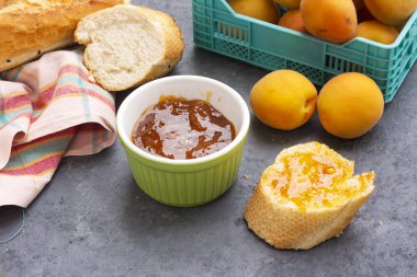 Kayısı reçelli kahvaltı ve bir dilim ekmek.