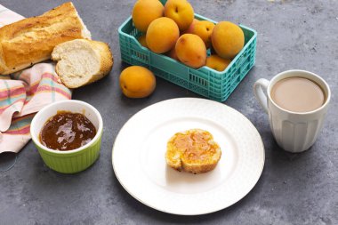 Kayısı reçelli kahvaltı ve bir dilim ekmek.