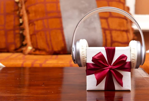 Müzik hediye konsepti. Kulaklıklar ve hediye kutusu. Selamlarınız için alan, tatil konsepti ile en iyi görünüm