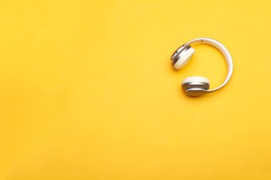 Bluetooth grisi, sarı arka planda beyaz kulaklık.