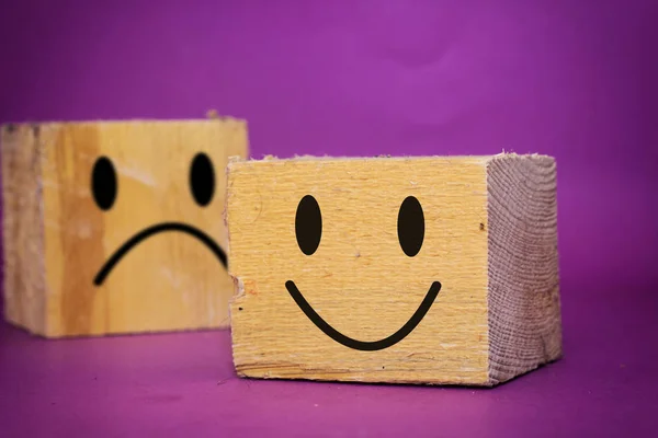 choose happy face and blurred sad face icon on wood cube, Service rating, satisfaction concept.