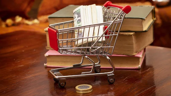 Shopping cart  of algeria cash money and coin,  e-commerce, e-payments and online shopping concept, and books