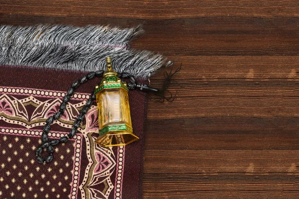 Ornamental Arabic lantern oud perfume with black rosary, prayer mat Ramadan Kareem Greeting Card. Ramadan Mubarak. Translated: Happy & Holy Ramadan. Month of fasting for Muslims.