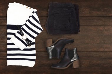 siyah jean, zebra pullover ve ahşap masada el saati ile siyah jean