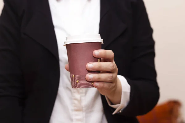 closeup business women  drinks coffee from a disposable cup