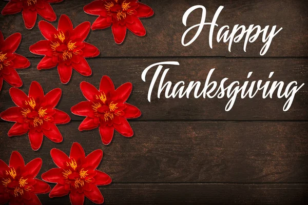 happy thanksgiving concept with red flowers on wooden table