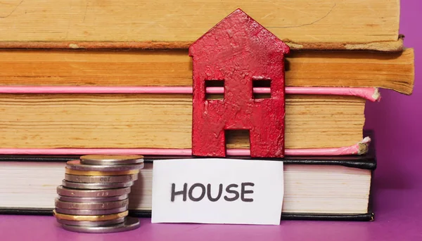 real estate agent, small red house books and coins , sell house business concept