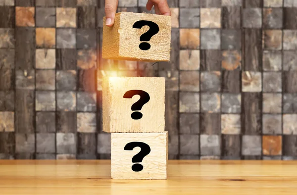 woman  hand placing piece of a big cube with question mark, Question mark cubes.