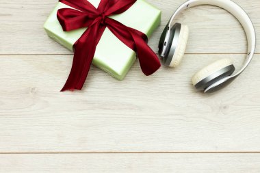 Müzik hediye konsepti. Kulaklıklar ve hediye kutusu. Selamlarınız için alan, tatil konsepti ile en iyi görünüm