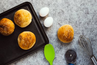 Tahtada susamlı ev yapımı hamburger çörekleri.