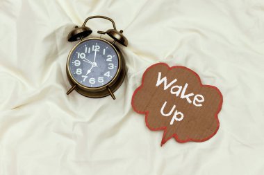 Alarm 7: 00 Beyaz çarşaf üzerinde uyanık sohbet baloncuğu ile saat