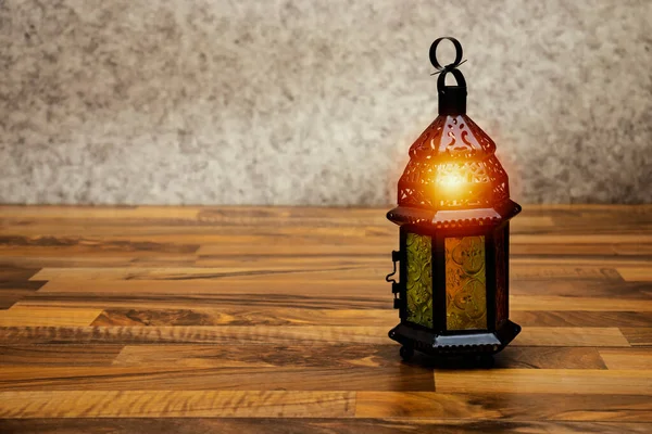 Yanan mumla süslenmiş Arapça bir fener. Bayram tebrik kartı. Müslümanların kutsal ayı için davet