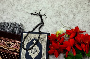 Kuran 'ın Arapça anlamı olan kutsal Kur' an ve siyah tespih ve namaz örtüsü.