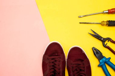 Renkli arka planda erkek ayakkabıları ve çeşitli araçlar