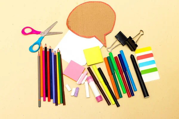 Back to school, school supplies and chat cardboard bubble on a yellow background. Protection of schoolchildren and students from the virus