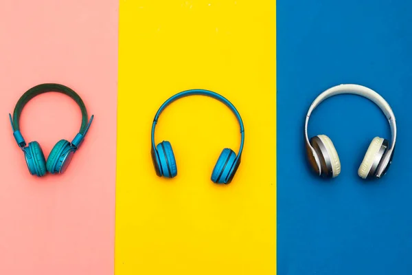 Τρία Διαφορετικά Ασύρματα Ακουστικά Ακουστικά Απομονωμένα Πολύχρωμο Φόντο — Φωτογραφία Αρχείου