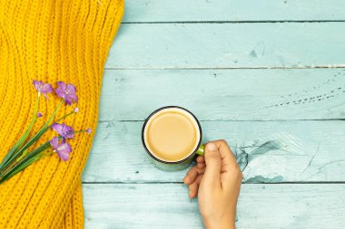 Kahve fincanı, yün eşarp ve ahşap masada çiçekler. Merhaba kış konsepti