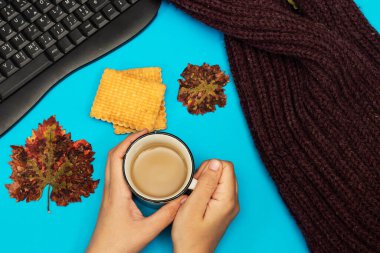 Kış ya da sonbahar konsepti, kadın bisküviyle sütlü kahve içiyor. 