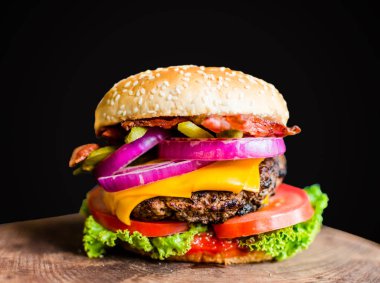 Siyah arka plan karşı ahşap bir masada Burger