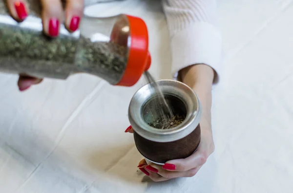 Mujer joven preparando té tradicional de yerba mate argentino —  Fotos de Stock