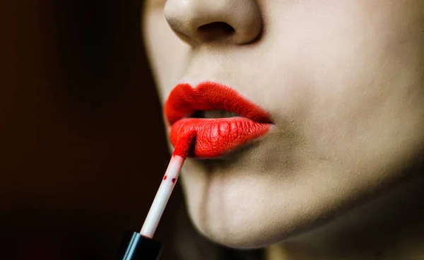 Young woman with smooth skin applying liquid red lipstick Royalty Free Stock Photos