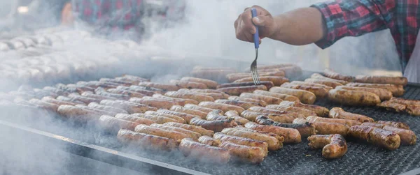 Argentina barbecue asado chorizo sausages and meat cooking on parilla grill