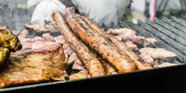 Argentina churrasco asado chouriço salsichas e carne cozinhar em parilla grill — Fotografia de Stock